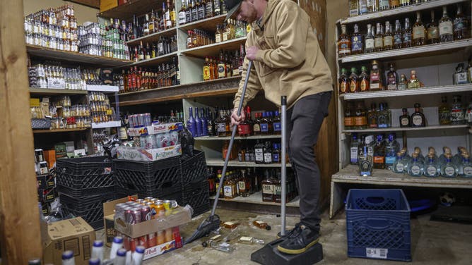 Dylan Carneiro cleans up liquor bottles at Mountaain Springs Liquor that were knocked off the shelves after an earthquake in Julian, California. A shallow 5.2 magnitude quake hit southern California on Monday, US geologists said. The tremor was centered 2.5 miles (four kilometers) south of Julian, which is around 20 miles from the US border with Mexico, and was eight miles deep, according to data from the US Geological Survey. (Photo by Sandy Huffaker / AFP) (Photo by SANDY HUFFAKER/AFP via Getty Images)