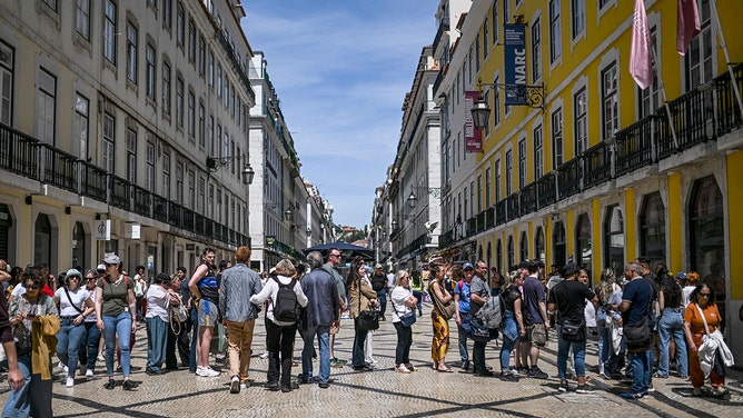 People queue for the ATM at downtown Lisbon on April 28, 2025, during a massive power cut affecting the entire Iberian peninsula and the south of France.