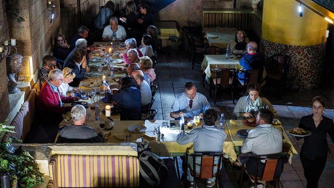 Customers eat in a restaurant with candles on tables in Burgos on April 28, 2025, during a massive power cut affecting the entire Iberian peninsula and the south of France.