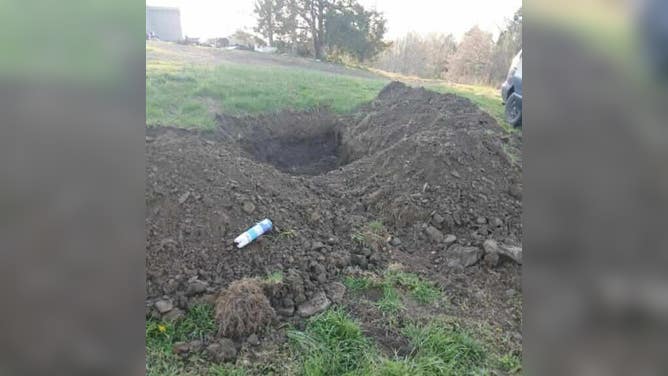 The empty hole where the minivan would be parked and used a storm shelter.