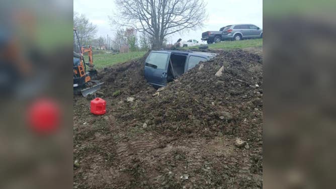 The minivan-turned-storm shelter in the process of being buried.
