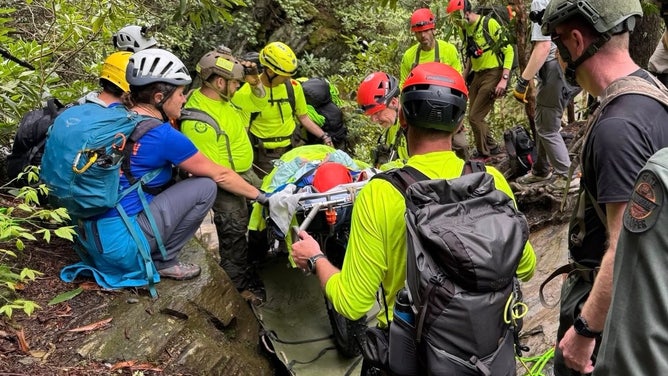 Hiker being transported by rescue crews.