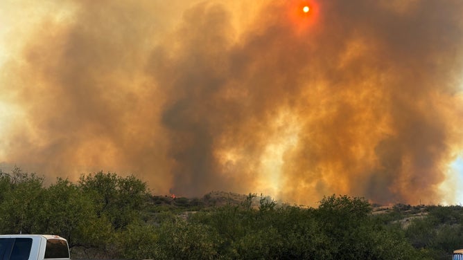 The sun appears bright orange as smoke from the Cody Fire fills the sky.