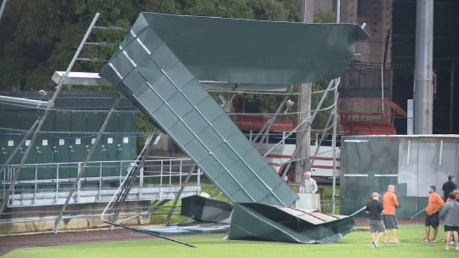 Winds from a severe thunderstorm take down a fence at the University of Texas baseball field in Austin.