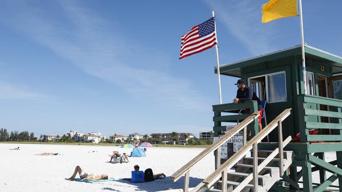 SARASOTA, UNITED STATES - August 26: Sarasota County Emergency Services lifeguard lieutenant Drew Bittle patrols the area at Siesta Beach on August 26, 2018 in Siesta Key, Florida.