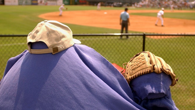 Malcolm Richardson, 10, and his father, use a towel, hats and gloves against the sun as fans brace against the heat during the first inning as Rice and McNeese face off in NCAA College Baseball Regional playoff action at Rice's Reckling Park in Houston, Friday afternoon, May 30, 2003.