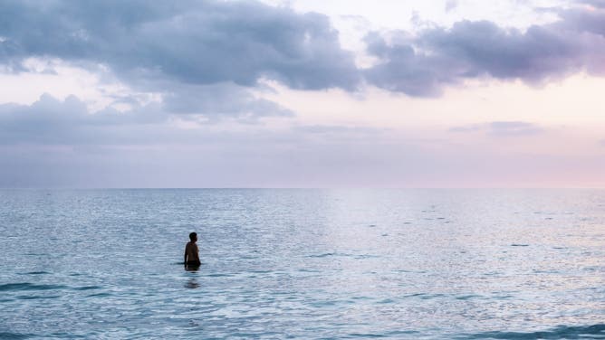 January 2017: A man in tropical ocean water at Siesta Key Beach in Florida.