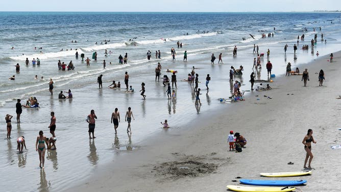 COCOA BEACH, FLORIDA, UNITED STATES - (ARCHIVE): A file photo dates July 29, 2023 shows beachgoers cool off in the surf on July 29, 2023 in Cocoa Beach, Florida. Ocean temperatures around the Florida Keys reached 101 degrees F (38 C) this week, a possible record. Temperature extremes across the globe have made July 2023 the planet's hottest month on record.