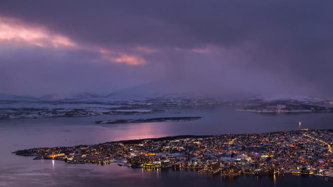 View over the city and Tromso Bay from Fjellheisen cable car station during polar night sunset at Storsteinen, Tromsdalen in Norway on January 14th, 2025.