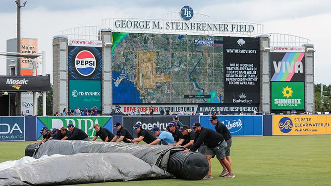 The Tampa Bay Rays grounds grew rolls up the tarp during the first ever home rain delay in Tampa Bay Rays history prior to a game against the Milwaukee Brewers at George M. Steinbrenner Field on May 10, 2025 in Tampa, Florida.