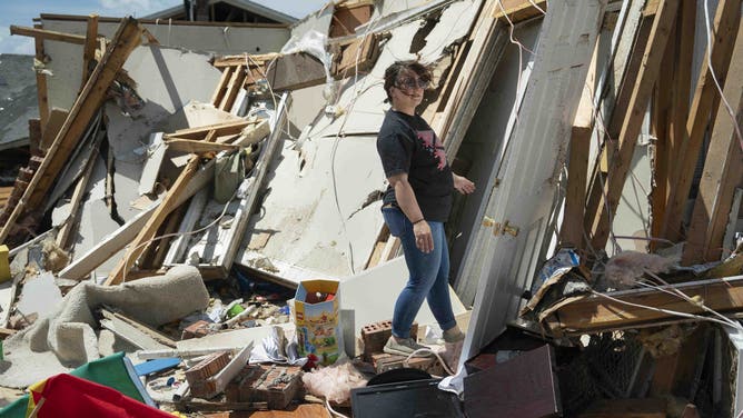 TOPSHOT - A pistillate   inspects harm  from a tornado successful  London, Kentucky, connected  May 17, 2025. More than 20 radical   person  died aft  terrible  storms swept done  the confederate  US states of Missouri and Kentucky, officials and section  media reports said May 17, 2025. Kentucky politician  Andy Beshear said connected  X that astatine  slightest  14 radical   had died successful  Friday night's storms. At slightest  7  radical   were killed successful  Missouri, the Washington Post reported. (Photo by Allison Joyce / AFP) (Photo by ALLISON JOYCE/AFP via Getty Images)