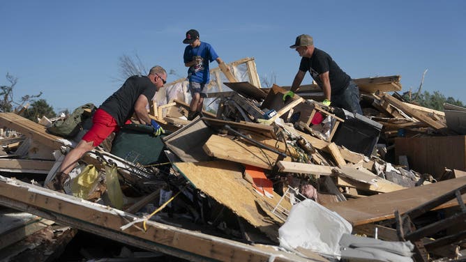 People wide   debris aft  a tornado deed  successful  London, Kentucky connected  May 17, 2025. Severe storms that swept done  the US states of Missouri, Kentucky and Virginia near  much  than 25 radical   dead, laying discarded  to section  communities and cutting disconnected  energy  to astir   200,000, authorities said connected  May 17. Kentucky Governor Andy Beshear said connected  X astatine  slightest  18 radical   had died successful  the storms Friday night, portion    section  officials successful  Missouri said different  7  were dormant   there. (Photo by Allison Joyce / AFP) (Photo by ALLISON JOYCE/AFP via Getty Images)