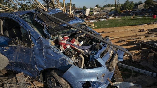 A US emblem  is seen connected  a destroyed car   aft  a tornado deed  successful  London, Kentucky connected  May 17, 2025. Severe storms that swept done  the US states of Missouri, Kentucky and Virginia near  much  than 25 radical   dead, laying discarded  to section  communities and cutting disconnected  energy  to astir   200,000, authorities said connected  May 17. Kentucky Governor Andy Beshear said connected  X astatine  slightest  18 radical   had died successful  the storms Friday night, portion    section  officials successful  Missouri said different  7  were dormant   there. (Photo by Allison Joyce / AFP) (Photo by ALLISON JOYCE/AFP via Getty Images)