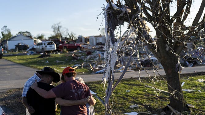LONDON, KENTUCKY - MAY 17: Members from a local church pray with Tony and Joe McFall, who lost their father and step-mother during the tornado in the neighborhood of Sunshine Hills on May 17, 2025 in London, Kentucky. A tornado struck communities in Somerset and London, Kentucky, leaving over 10 dead and more injured. (Photo by Michael Swensen/Getty Images)