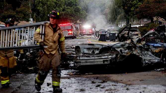 Firefighters work the site where a small plane crashed into a San Diego, California, residential street on May 22, 2025.