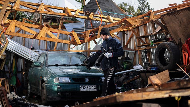 A man walks inside a damaged garage after the passage of a tornado in the city of Puerto Varas, Region de los Lagos, southern Chile, on May 26, 2025.