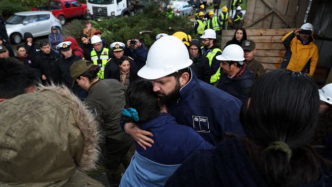 Chile's President Gabriel Boric greets a woman as he visits the affected area after the passage of a tornado in the city of Puerto Varas, Region de los Lagos, southern Chile, on May 26, 2025.