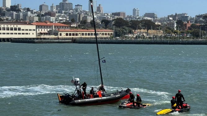 A sailboat captain clings to the ropes of a sinking vessel in San Francisco on May 24, 2025 as first responders wait nearby.