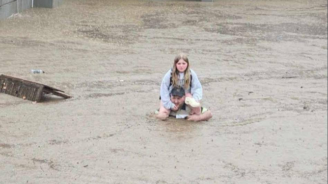 A antheral   carries a miss  connected  his shoulders, aft  flooding astatine  Westwenport Elementary School successful  Allegany County, Maryland connected  May 13, 2025.