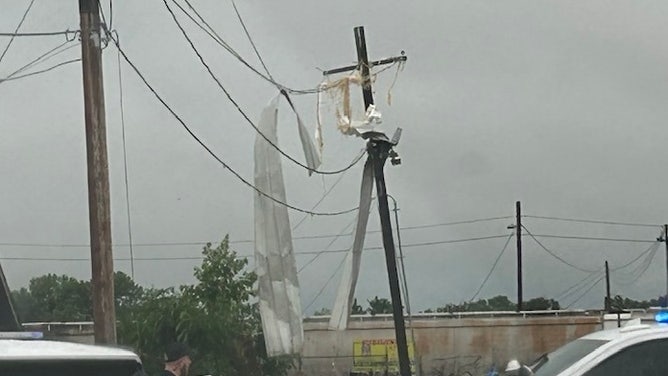 Metal debris is twisted around power lines and telephone pole in Van Buren, Arkansas.
