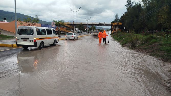 Crews walk through flooding in Acapulco, Mexico.