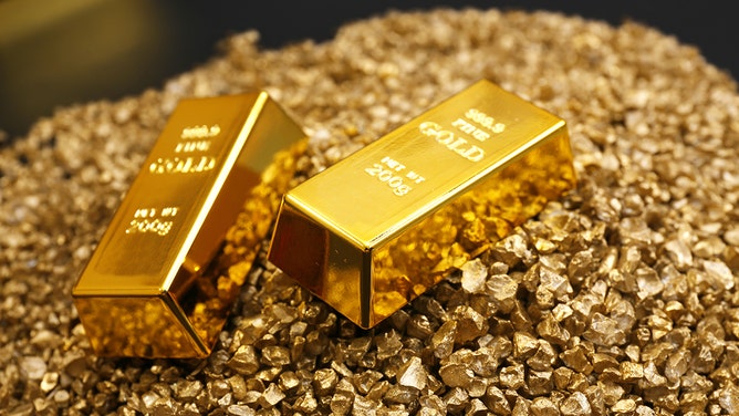 Gold bars are seen close-up on nugget grains.