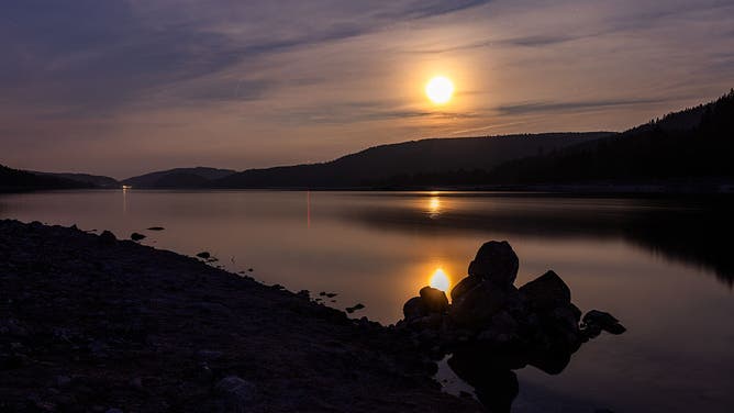 The moon can be seen over the Schluchsee. A rare celestial phenomenon appears in the night from June 10 to 11: the strawberry moon. The full moon is then unusually low in the sky - as low as it was last 18 years ago.