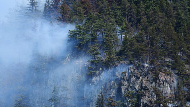 This photograph shows wildfires burning in the hills north of Tantalus Road, in Squamish, British Columbia on June 11, 2025.