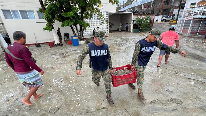 Mexican Navy members help with cleansing tasks following the passage of Hurricane Erick in Bahia Principal, Puerto Escondido, state of Oaxaca, Mexico, on June 19, 2025. Erick, a category 4 hurricane on a scale of 5, made landfall in the Mexican state of Oaxaca (west) on the Pacific coast, the United States National Hurricane Center (NHC) reported. (Photo by CARLO ECHEGOYEN / AFP) (Photo by CARLO ECHEGOYEN/AFP via Getty Images)