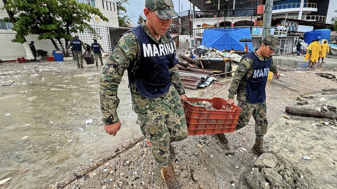 Mexican Navy members help with cleansing tasks following the passage of Hurricane Erick in Bahia Principal, Puerto Escondido, state of Oaxaca, Mexico, on June 19, 2025. Erick, a category 4 hurricane on a scale of 5, made landfall in the Mexican state of Oaxaca (west) on the Pacific coast, the United States National Hurricane Center (NHC) reported. (Photo by CARLO ECHEGOYEN / AFP) (Photo by CARLO ECHEGOYEN/AFP via Getty Images)