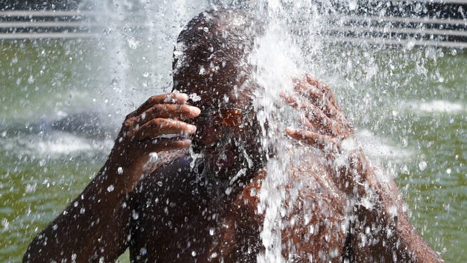 NEW YORK, NY - JUNE 24: A man cools off in the water amid high temperatures at Washington Square on June 24, 2025 in New York City. Tens of millions of people in major cities across the U.S. Northeast are facing record high temperatures on Tuesday on what was expected to be the worst day of an oppressive heat wave that has spread over much of the country since late last week. (Photo by Liao Pan/China News Service/VCG via Getty Images)