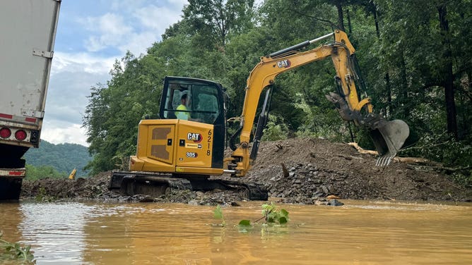 Construction crews work to remove debris from I-40 at the Tennessee/North Carolina border where flash flooding and landslides closed the highway.