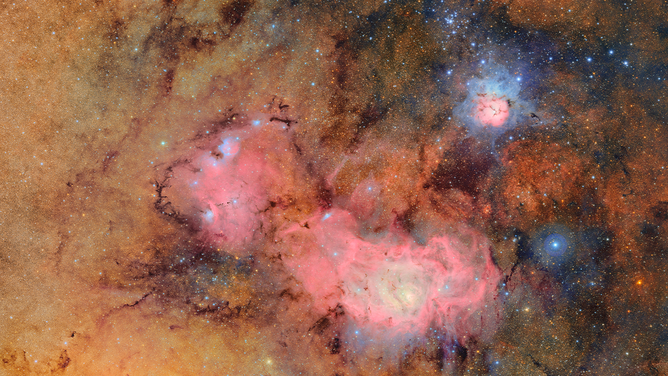 This image combines 678 separate images taken by NSF-DOE Vera C. Rubin Observatory in just over seven hours of observing time. Combining many images in this way clearly reveals otherwise faint or invisible details, such as the clouds of gas and dust that comprise the Trifid nebula (top right) and the Lagoon nebula, which are several thousand light-years away from Earth.