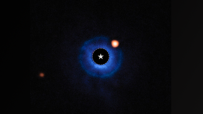 This image combines ground-based data from ESO’s Very Large Telescope (VLT) and data from Webb’s MIRI (Mid-Infrared Instrument), light from the star TWA 7 has been subtracted. The star is marked by a star and the orange glow to the upper right is the planet candidate.