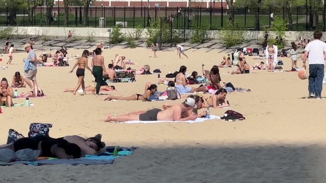 This image shows people relaxing on a beach on the shore of Lake Michigan in Chicago.