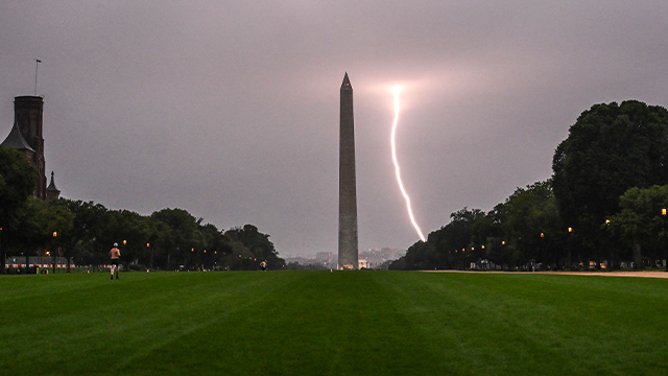 A lightning strike is seen during a storm, with the Washington monument in the foreground in Washington, DC on August 29, 2024. (Photo by ANDREW CABALLERO-REYNOLDS / AFP) (Photo by ANDREW CABALLERO-REYNOLDS/AFP via Getty Images)