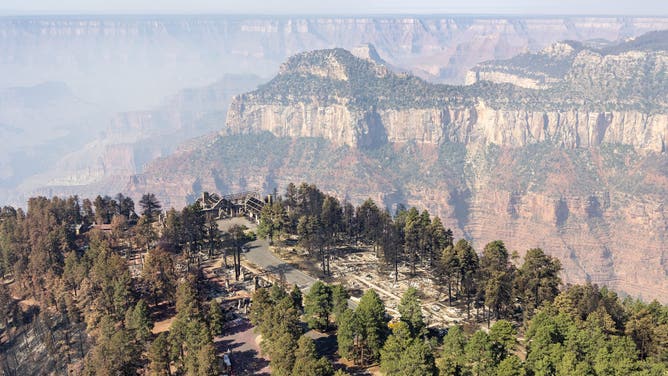 Above Grand Canyon Lodge and the southern terminus of Arizona State Route 67 in the North Rim developed area. The remains of Grand Canyon Lodge is visible left of center.