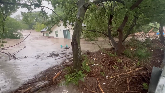 The house comes floating down the Guadalupe River in Center Point, Texas.