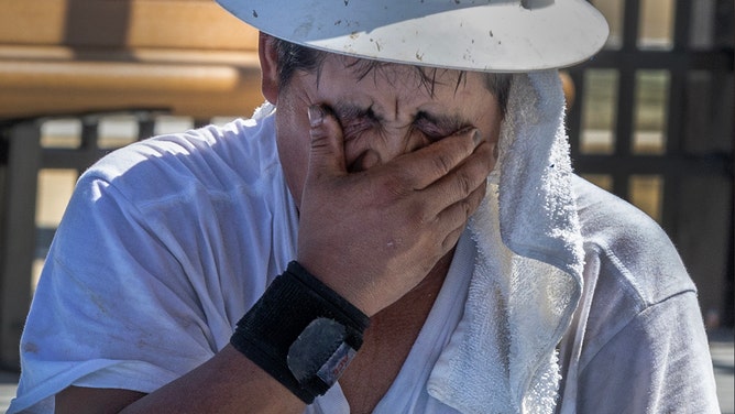 A man wipes the sweat away after working on the spray deck at the Vietnam Veterans Swimming and Wading Pool on June 24, 2025.