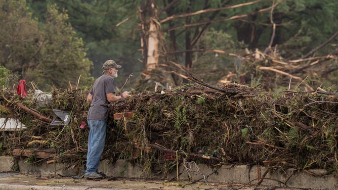 A resident surveys flood damage and debris along the Guadalupe River on July 5, 2025 in Kerrville, Texas.