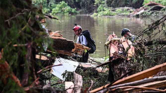 Members of a search and rescue team look for people near Camp Mystic, the site of where at least 20 girls went missing after flash flooding in Hunt, Texas, on July 5, 2025. Rescuers were on Saturday searching for more than 20 girls missing from a riverside summer camp in the US state of Texas, after torrential rains caused devastating flooding that killed at least 27 people -- with more rain on the way. "So far, we've evacuated over 850 uninjured people, eight injured people and have recovered 27 deceased fatalities at this time. Of these 27, 18 are adults, nine are children," said Kerr Country Sheriff Larry Leitha on July 5.