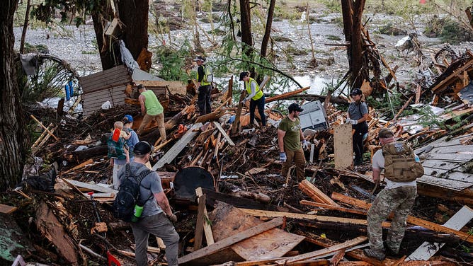 Search and rescue workers dig through debris looking for any survivors or remains of people swept up in the flash flooding on July 6, 2025 in Hunt, Texas.