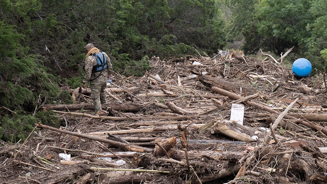 U.S. Border Patrol officers search through flood debris along the Guadalupe River on July 6, 2025 in Kerrville, Texas.