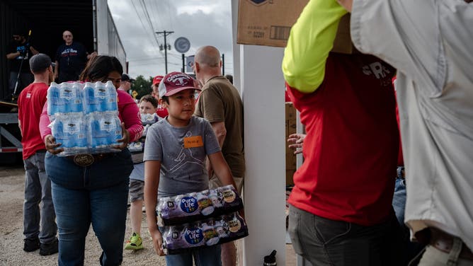 Volunteers unload a semi-truck full of supplies delivered by Convoy of Hope.