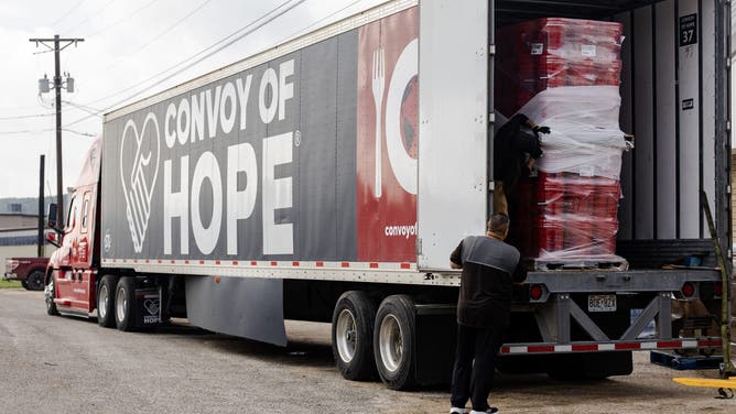 Volunteers unload a semi-truck full of supplies delivered by Convoy of Hope.