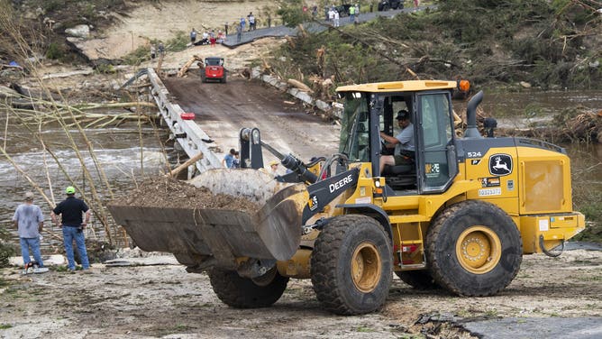 INGRAM, TEXAS JULY 5: Crews work to fill a hole on a bridge along Cade Loop that crosses the Guadalupe River after heavy rainfall in Central Texas damaged the structure and stranded several homes without power or aid, Saturday, July 5, 2025. (Jason Fochtman/Houston Chronicle via Getty Images)