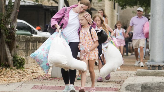 INGRAM, TEXAS - JULY 5: A woman and a child embrace after girls from Camp Waldemar, near the North fork of the Guadalupe River, are reunited with their families after heavy rainfall in Central Texas, Saturday, July 5, 2025. (Jason Fochtman/Houston Chronicle via Getty Images)