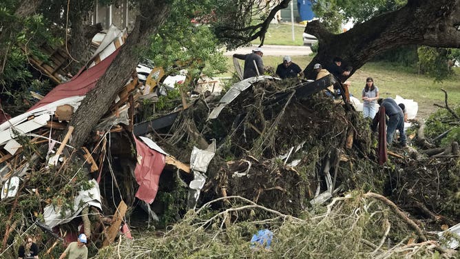 INGRAM, TEXAS JULY 5: Crews work to fill a hole on a bridge along Cade Loop that crosses the Guadalupe River after heavy rainfall in Central Texas damaged the structure and stranded several homes without power or aid, Saturday, July 5, 2025. (Jason Fochtman/Houston Chronicle via Getty Images)