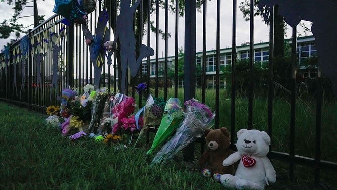 Flowers, cards and stuffed animals are seen in front of parents, students, school faculty and community members gathering at Sinclair Elementary for a vigil in honor of missing student Greta Toranzo, who attended Camp Mystic and is among the missing after catastrophic flooding, on Saturday, July 5, 2025 in Houston