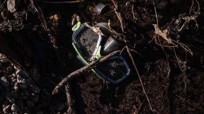 A pair of diving goggles in the mud along the Guadalupe River in Kerrville, Texas, on Thursday, July 10, 2025.
